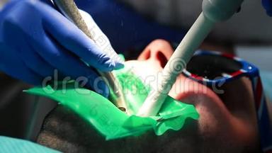一个女人拿着一个牙医在牙医`办公室里钻孔病人的<strong>牙齿</strong>，并用栅栏把<strong>牙齿</strong>的残余物围起来。